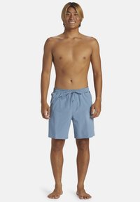 Bañador azul en tejido ligero con cintura elástica y cordón. Con bolsillos laterales y un corte holgado.