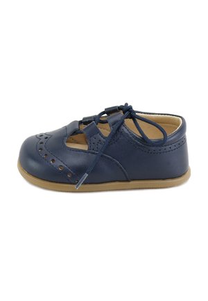 Zapato de bebé de cuero azul marino con suela beige, detalles decorativos perforados y cierre con cordones sobre fondo blanco.