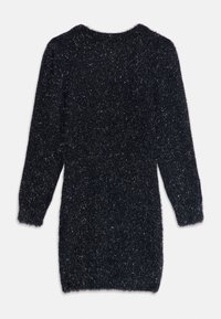 Svart, fluffy kjole med lange ermer, som har en myk tekstur og subtile metalliske fibre. Rund hals og lengde til midten av låret.
