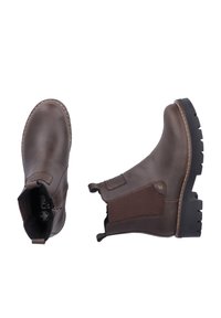 Paire de bottines Chelsea en cuir marron avec semelles épaisses noires, panneaux latéraux élastiques et languettes à tirer, présentées vues de dessus et de côté.