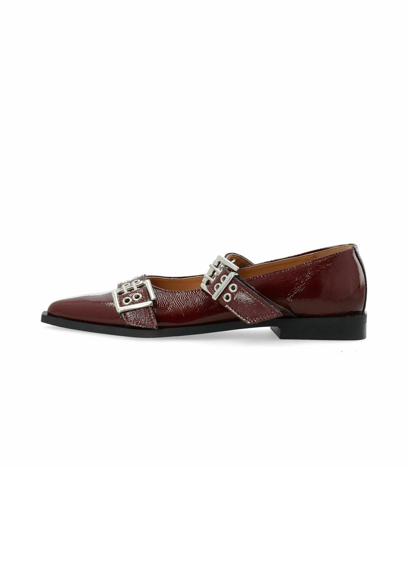 Chaussure plate en cuir verni bordeaux avec bout pointu et deux brides à boucle argentée traversant le dessus.