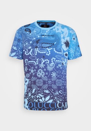 Short-sleeve blue t-shirt with intricate paisley and floral patterns in varying shades of blue and "Carlo Colucci" text on the chest.