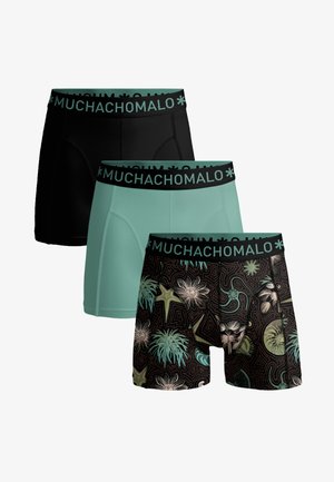 Tri pánske boxerky v čiernej, tyrkysovej a čiernej farbe s tropickými kvetinovými a hviezdicovými vzormi, všetky s čiernymi pásikmi na páse označenými nápisom "MUCHACHOMALO".