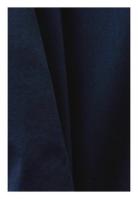 Tissu bleu foncé avec un motif de tissage diagonal visible et des plis doux créant des zones ombragées.