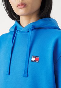Tommy Jeans BADGE HOODIE UNISEX - Jersey con capucha - meridian blue