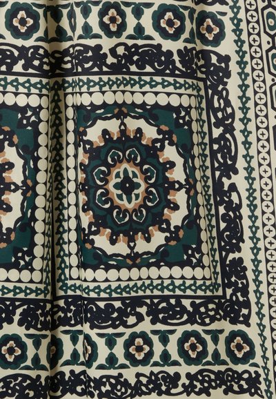 Tejido estampado con un diseño floral y geométrico en verde, azul marino y crema, con bordes intrincados y acentos circulares.