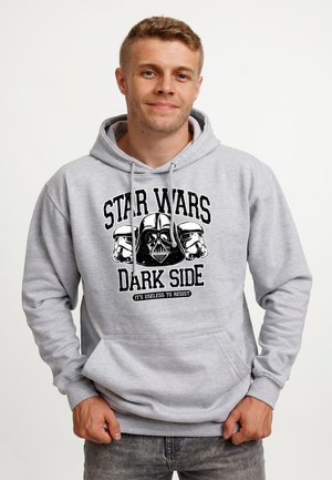Uomo che indossa una felpa con cappuccio grigio chiaro con grafica Star Wars Dark Side che raffigura i caschi di Darth Vader e stormtrooper.