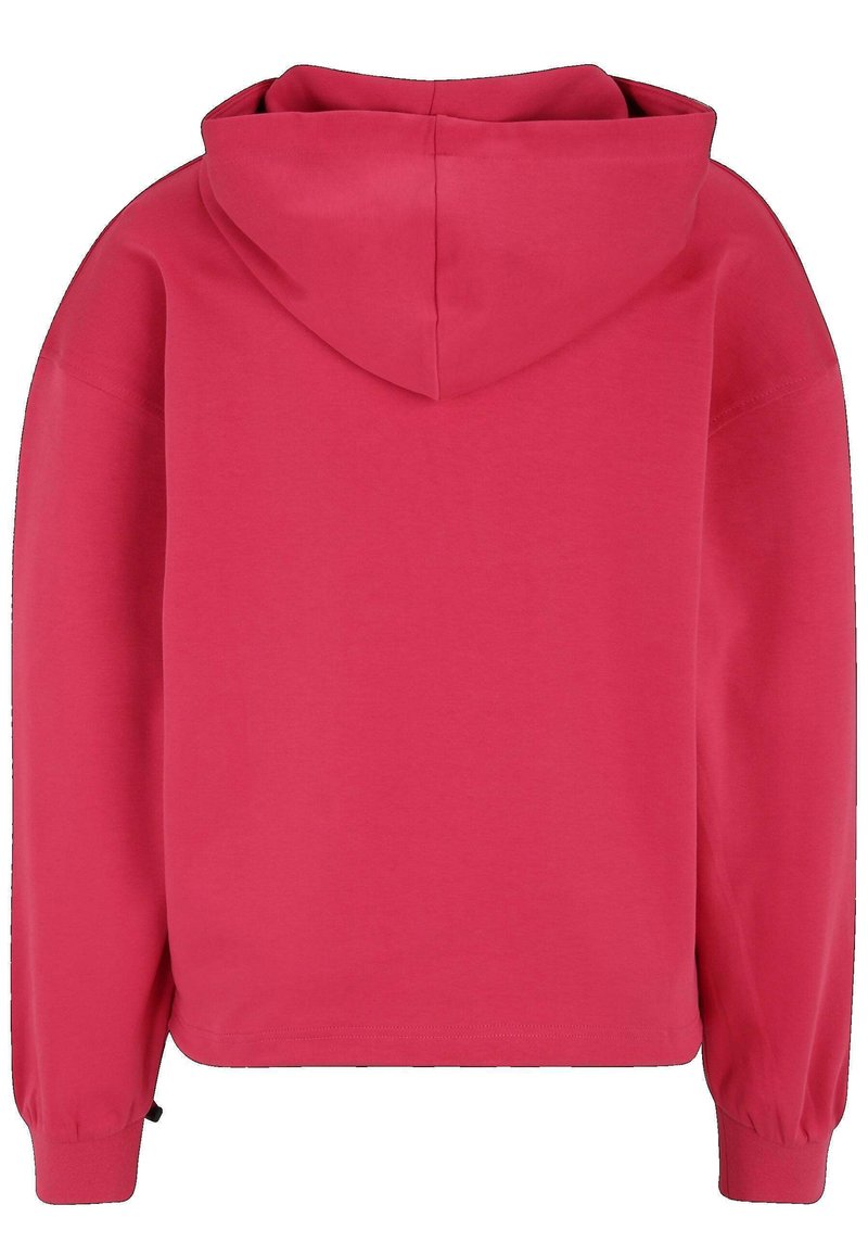 Krótkia, sweter w jasnoróżowym kolorze. Posiada dużą kaptur, długie rękawy z elastycznymi mankietami oraz gładką, miękką teksturę.