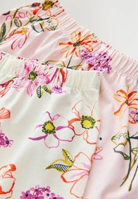 Stoff mit Blumenmuster auf pinkem Hintergrund. Elastischer Bund in leuchtenden Farben, darunter Pink, Gelb und Grün. Sanfte Textur.