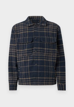 Navy blue and brown plaid button-up shirt jacket with two chest flap pockets and a classic collar, long sleeves, and a straight hem.