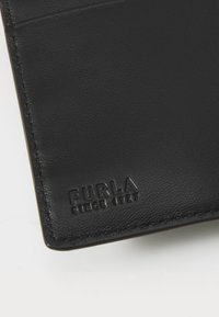 Portafoglio in pelle nera con superficie testurizzata, dotato di dettaglio impresso "FURLA SINCE 1927", bordi cuciti e un design elegante.