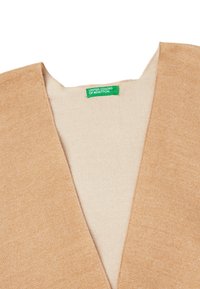 Béžový svetr s výstřihem do V, texturovaná tkanina a krémový interiér. Obsahuje zelenou nálepku s nápisem "UNITED COLORS OF BENETTON."