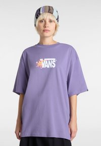 T-shirt oversize viola in morbido cotone, con il logo bianco "VANS" e dettagli grafici colorati sul petto.