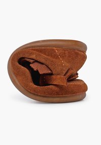 Bruine suède schoenen met een afgeronde vorm, zachte textuur en een gevouwen ontwerp. Beschikt over een bruine rubberen zool en minimale stikseldetails.
