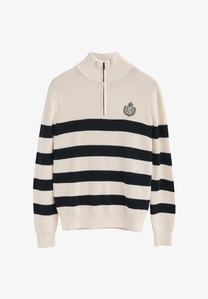 Hoge nektrui in crème met marineblauwe en witte strepen. Voorzien van een ritskraag en geborduurd logo op de borst. Geribbelde textuur.