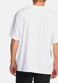 Hvid bomulds t-shirt med kort ærmer, afslappet pasform og rund hals. Bagsiden er almindelig uden mønstre eller pynt.