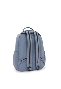 Modrý nylonový batoh s dvojitými šedými a černými pruhovanými popruhy, zaoblenými okraji, bočními kapsami a horním uchem. Hladký povrch a lehký design.