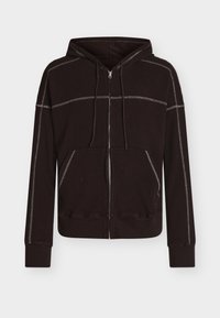 Καφέ φούτερ με φερμουάρ από υφή υφάσματος, με κουκούλα, τσέπες μπροστά και αντιθετικές λεπτομέρειες ραφών κατά μήκος των ραφών.