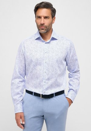 Lichtblauwe overhemd met lange mouwen heeft een paisleypatroon, een button-down kraag en een getailleerde pasvorm. Gecombineerd met lichtblauwe broek en een zwarte riem.