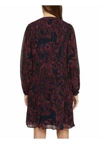 Kortärmad klänning i mörk marinblått med ett vinrött blommönster, med en lös passform och draperingar vid ärmarna och midjan.