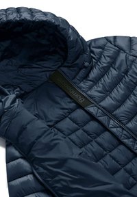 Giacca puffer blu navy con texture trapuntata, cappuccio, zip a tutta lunghezza e accentuazione in tessuto nero brandizzato lungo la zip.