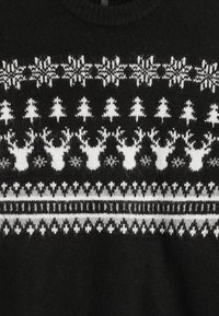 Suéter negro con patrón Fair Isle en blanco que presenta renos, árboles y copos de nieve. Textura de punto con un cuello redondo.
