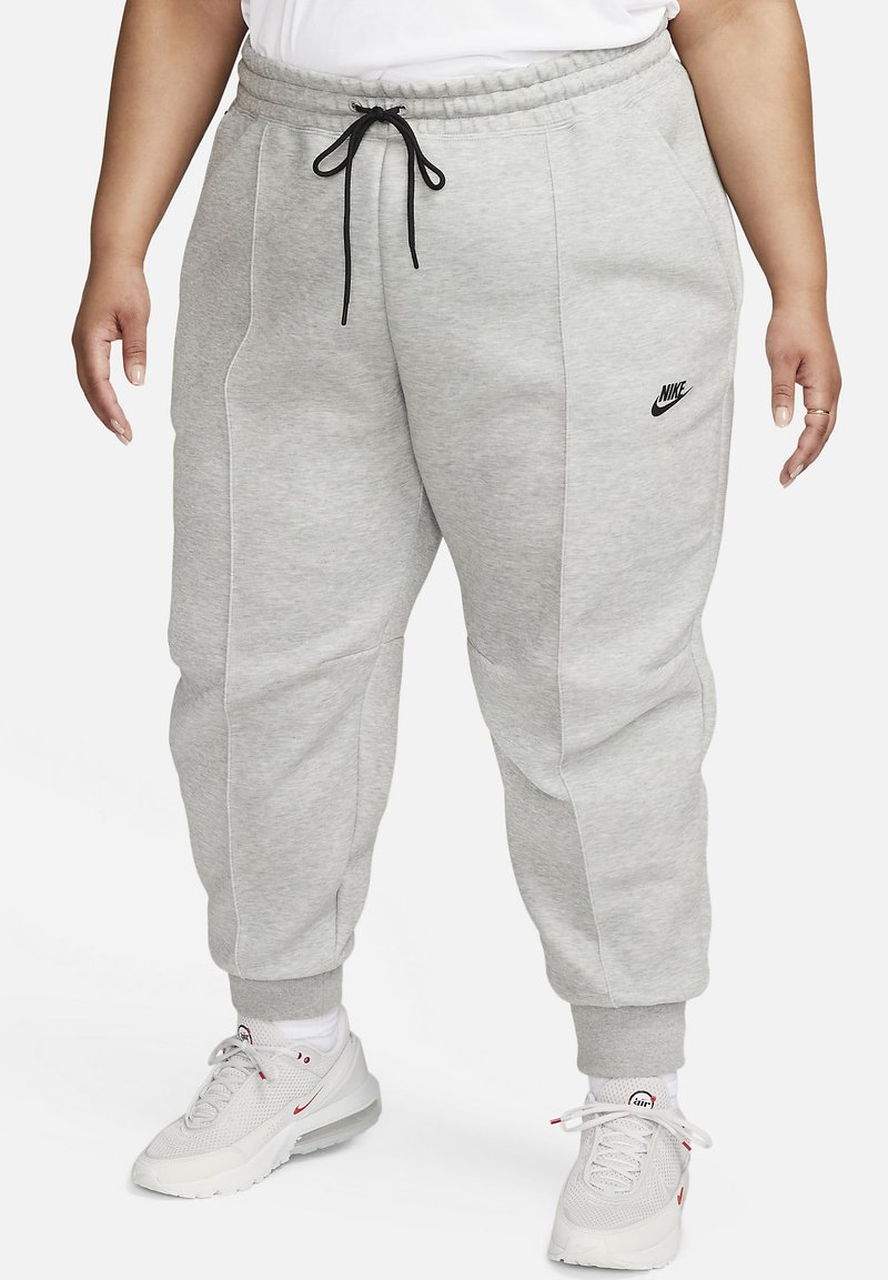 Graue Jogginghose mit lässiger Passform, elastischem Bund und Kordelzug. Verfügt über eine Seitentasche und ein kleines schwarzes Nike-Logo am linken Oberschenkel.