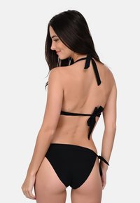 Black bikini featuring a halter neck design with ties. The top has a back bow detail, while the bottom includes adjustable side ties for fit.