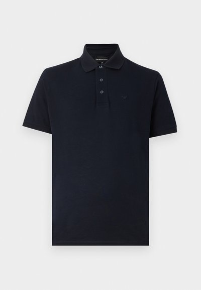 Μαύρο polo με κοντά μανίκια, γιακά, τρία κουμπιά και διακριτικό λογότυπο της μάρκας αριστερά στο στήθος.