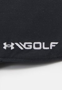 Juodas audinys su baltomis siuvinėtomis raidėmis "H" ir "GOLF", lygia tekstūra ir paprastu dizainu.