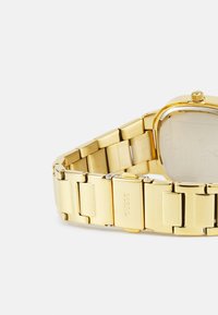 Guldfarvet armbåndsur med et rektangulært urkasse, metal-link armbånd og indgraveret mærkedetail på låsen. Glat, poleret overflade.