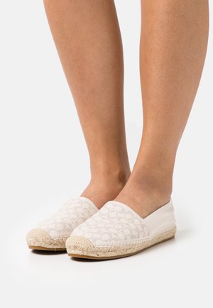 Le scarpe espadrillas bianche slip-on presentano una toma a motivi e una suola in corda di juta testurizzata. Il design è minimalista con punta arrotondata.