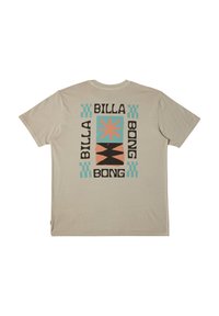 Camiseta beige con un gráfico en la parte posterior que presenta el texto "BILLA BONG", formas geométricas en turquesa, negro y melocotón. Material de algodón suave.