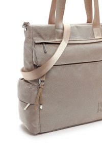 Beige texturerad tygväska med dubbla handtag och justerbar axelrem, med en övre dragkedja och ytterficka med silverdetaljer.