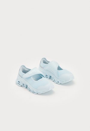 Chaussures de sport bleu clair avec tige en mesh et fermeture à scratch ajustable, dotées de semelles épaisses creuses texturées pour la ventilation et le soutien.