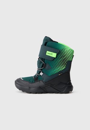 Botte d'hiver montante verte et noire avec bride en velcro, lacets, semelle texturée et étiquette "Gore-Tex" sur le côté pour l'imperméabilité.