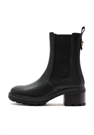 Black leather ankle boot with elastic side panels, rounded toe, and a textured block heel. Detailed stitching and a pull tab at the back.