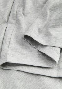 Lys grå bomullstoff med en myk tekstur, med brettede kanter og søm uten sømmer. Overflaten viser et subtilt mønster.