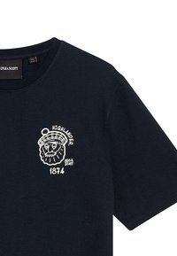 Marineblå kortærmet t-shirt med rund hals, der har et hvidt Highlander grafik og "1874" tekst på venstre brystområde. Materiale i bomuld.
