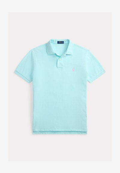 Polo bleu clair en coton, avec un col classique, trois boutons, des manches courtes et un petit logo rose sur la poitrine.