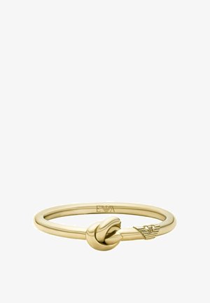 Armband aus goldfarbenem Metall mit zentralem Knotendesign und graviertem Emblem an einem Ende, vor weißem Hintergrund.