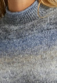Maglione a collo alto in maglia con effetto ombre blu e grigio, realizzato in un morbido tessuto mix di lana con texture, caratterizzato da un colletto a costine e un design senza cuciture.