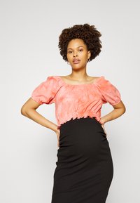 Blusa cor-de-rosa cropped com mangas bufantes e barra com volantes, combinada com uma saia justa preta, apresentando uma textura de tecido suave e design simples.