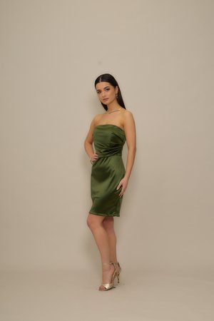 Olíva zöld, pánt nélküli szatén ruha, testhez simuló szabással és a deréknál gyűrt részlettel, aranyszínű magassarkú szandállal párosítva.