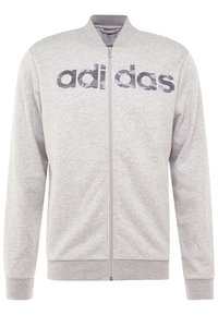 Sweatshirt zippé gris avec un col, arborant le mot "adidas" en lettres capitales gris foncé sur la poitrine. Texture de tissu douce.