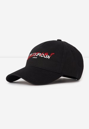 Black baseball cap with curved brim, featuring white and red embroidered text "KOOPLEAF?" and "PARIS" on front panel.