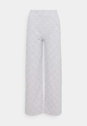 Pantalon large gris clair avec un motif répétitif de losanges blancs comprenant un « G » stylisé à l’intérieur de chaque losange.