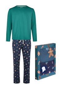 Haut teal à manches longues avec un pantalon bleu marine, décoré d'un motif de pain d'épice et de cannes en sucre, à côté de l'emballage d'un ensemble de pyjama assorti.