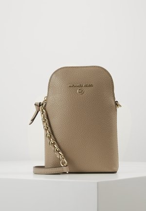 Brun tekstureret læder Michael Kors crossbody taske med guld kæderefrem og logo foran, stående på hvid overflade mod lys baggrund.