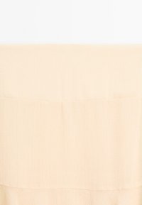 Tessuto beige chiaro con una sottile texture a coste, caratterizzato da un design liscio e piegato e bordi puliti, ideale per usi versatili.